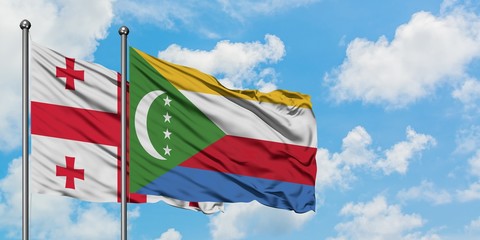 Georgia and Comoros flag waving in the wind against white cloudy blue sky together. Diplomacy concept, international relations.