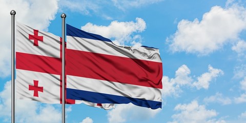 Georgia and Costa Rica flag waving in the wind against white cloudy blue sky together. Diplomacy concept, international relations.