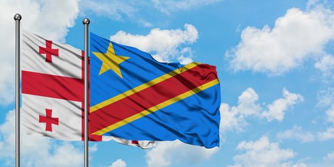 Georgia and Congo flag waving in the wind against white cloudy blue sky together. Diplomacy concept, international relations.