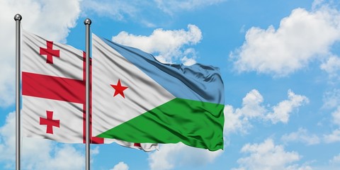 Georgia and Djibouti flag waving in the wind against white cloudy blue sky together. Diplomacy concept, international relations.
