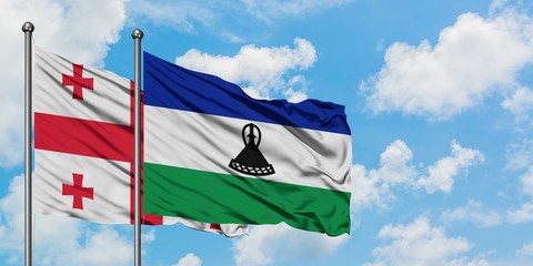 Georgia and Lesotho flag waving in the wind against white cloudy blue sky together. Diplomacy concept, international relations.