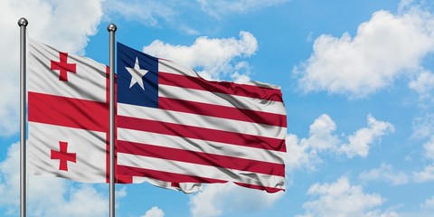 Georgia and Liberia flag waving in the wind against white cloudy blue sky together. Diplomacy concept, international relations.