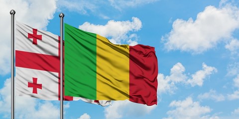 Georgia and Mali flag waving in the wind against white cloudy blue sky together. Diplomacy concept, international relations.