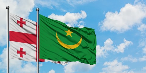 Georgia and Mauritania flag waving in the wind against white cloudy blue sky together. Diplomacy concept, international relations.