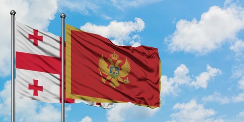 Georgia and Montenegro flag waving in the wind against white cloudy blue sky together. Diplomacy concept, international relations.
