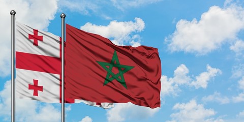 Georgia and Morocco flag waving in the wind against white cloudy blue sky together. Diplomacy concept, international relations.