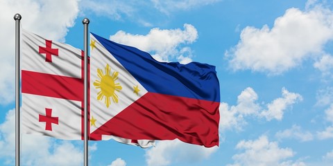 Georgia and Philippines flag waving in the wind against white cloudy blue sky together. Diplomacy concept, international relations.