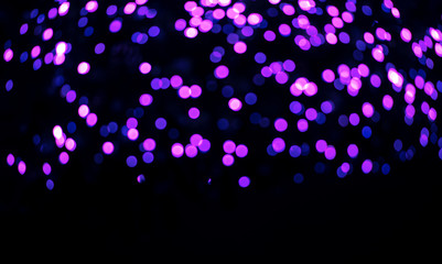 Purple, pink, blue bokeh on a black background. Abstraction