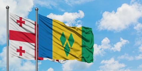 Georgia and Saint Vincent And The Grenadines flag waving in the wind against white cloudy blue sky...