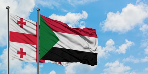 Georgia and Sudan flag waving in the wind against white cloudy blue sky together. Diplomacy concept, international relations.