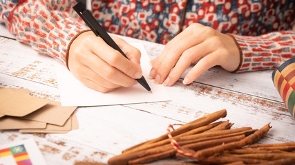 Closeup, hands of a beautiful and stylish woman write letter and  greeting cards to friends and...