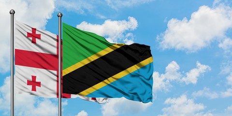 Georgia and Tanzania flag waving in the wind against white cloudy blue sky together. Diplomacy...