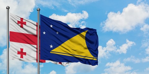 Georgia and Tokelau flag waving in the wind against white cloudy blue sky together. Diplomacy concept, international relations.