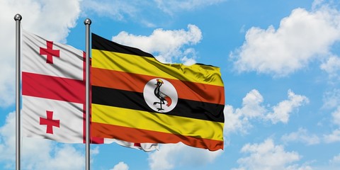 Georgia and Uganda flag waving in the wind against white cloudy blue sky together. Diplomacy concept, international relations.