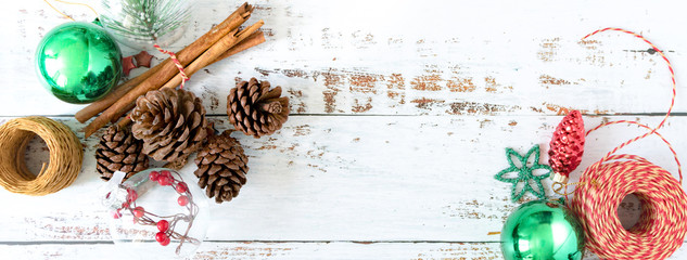 Christmas Banner: Top view of Christmas ornaments such as pine cone, cinnamon stick, red and white paper rope arranging in nice composition with copy space. 2020 Holidays seasons greetings crafts. © myboys.me