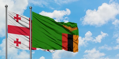 Georgia and Zambia flag waving in the wind against white cloudy blue sky together. Diplomacy concept, international relations.