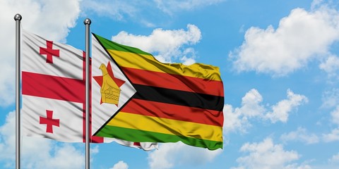 Georgia and Zimbabwe flag waving in the wind against white cloudy blue sky together. Diplomacy concept, international relations.