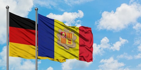 Germany and Andorra flag waving in the wind against white cloudy blue sky together. Diplomacy...