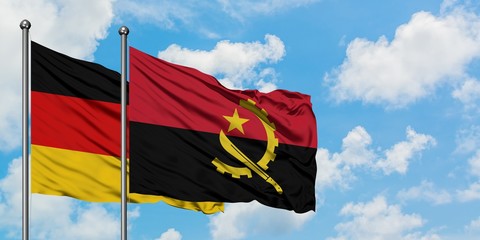 Germany and Angola flag waving in the wind against white cloudy blue sky together. Diplomacy concept, international relations.