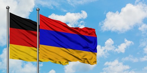 Germany and Armenia flag waving in the wind against white cloudy blue sky together. Diplomacy concept, international relations.