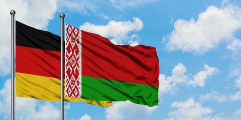 Germany and Belarus flag waving in the wind against white cloudy blue sky together. Diplomacy concept, international relations.