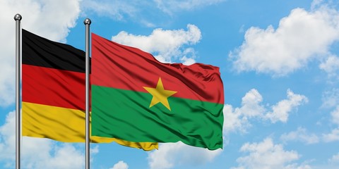 Germany and Burkina Faso flag waving in the wind against white cloudy blue sky together. Diplomacy...