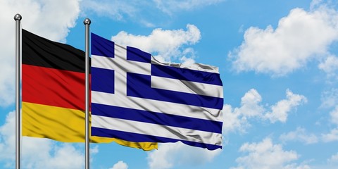 Germany and Greece flag waving in the wind against white cloudy blue sky together. Diplomacy concept, international relations.