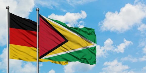 Germany and Guyana flag waving in the wind against white cloudy blue sky together. Diplomacy concept, international relations.