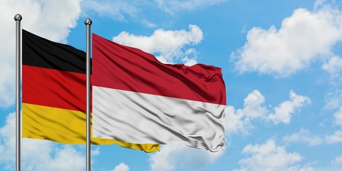 Germany and Indonesia flag waving in the wind against white cloudy blue sky together. Diplomacy concept, international relations.