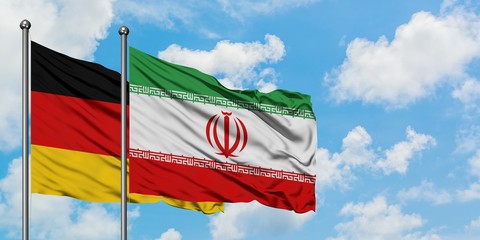 Germany and Iran flag waving in the wind against white cloudy blue sky together. Diplomacy concept,...