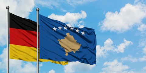 Germany and Kosovo flag waving in the wind against white cloudy blue sky together. Diplomacy concept, international relations.