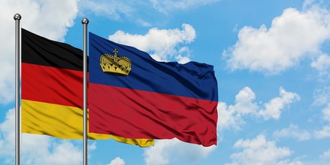 Germany and Liechtenstein flag waving in the wind against white cloudy blue sky together. Diplomacy concept, international relations.