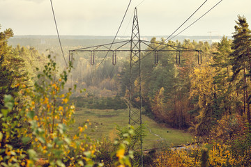 High-voltage powerlines and high-voltage pylons transporting  electric power in a lane through a...