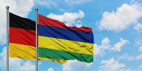 Germany and Mauritius flag waving in the wind against white cloudy blue sky together. Diplomacy concept, international relations.