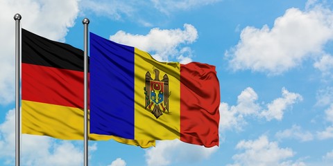 Germany and Moldova flag waving in the wind against white cloudy blue sky together. Diplomacy...