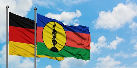 Germany and New Caledonia flag waving in the wind against white cloudy blue sky together. Diplomacy concept, international relations.