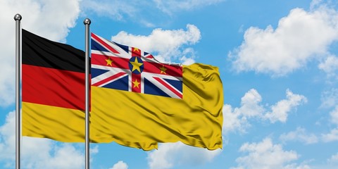 Germany and Niue flag waving in the wind against white cloudy blue sky together. Diplomacy concept, international relations.