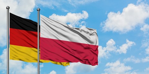 Germany and Poland flag waving in the wind against white cloudy blue sky together. Diplomacy concept, international relations.