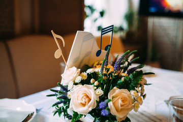 Table decorated with notes and flowers in a small piano