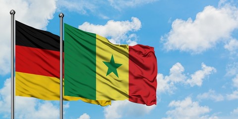 Germany and Senegal flag waving in the wind against white cloudy blue sky together. Diplomacy concept, international relations.