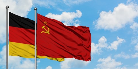 Germany and Soviet Union flag waving in the wind against white cloudy blue sky together. Diplomacy concept, international relations.