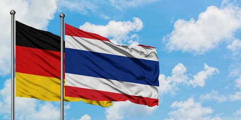 Germany and Thailand flag waving in the wind against white cloudy blue sky together. Diplomacy...