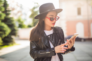 Asian woman using smart phone on city street