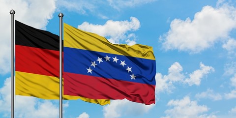 Germany and Venezuela flag waving in the wind against white cloudy blue sky together. Diplomacy concept, international relations.