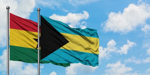Ghana and Bahamas flag waving in the wind against white cloudy blue sky together. Diplomacy...
