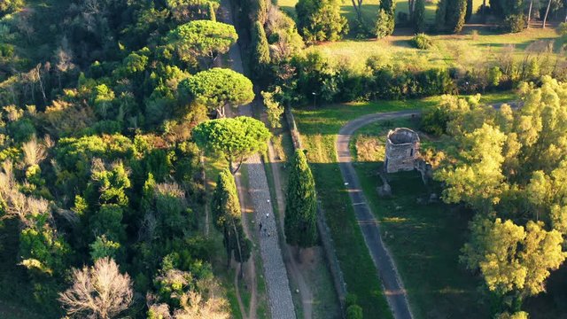 Aerial view of ancient Via Appia Antica with green trees, meadows, houses and pathways in Rome, Italy