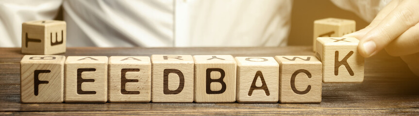 Wooden blocks with the word Feedback and critic. The concept of the rating of hotels and...