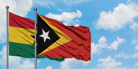 Ghana and East Timor flag waving in the wind against white cloudy blue sky together. Diplomacy...