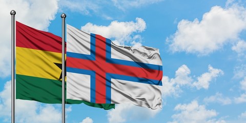 Ghana and Faroe Islands flag waving in the wind against white cloudy blue sky together. Diplomacy concept, international relations.