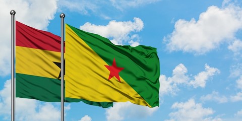 Ghana and French Guiana flag waving in the wind against white cloudy blue sky together. Diplomacy concept, international relations.